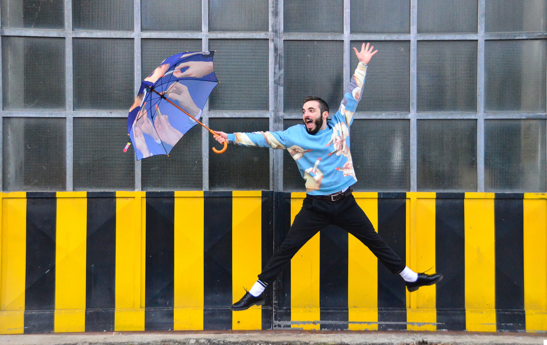 Foto di Francesco Rigoni che salta con un ombrello in mano in un quartiere di Milano